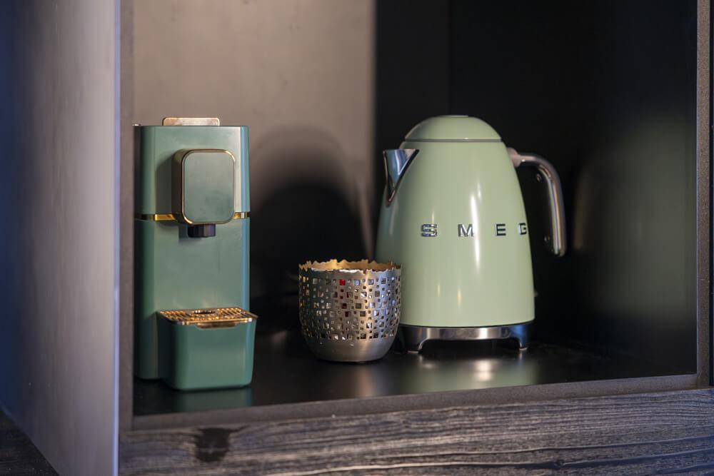 Elegante angolo caffè con macchina verde e bollitore vintage.