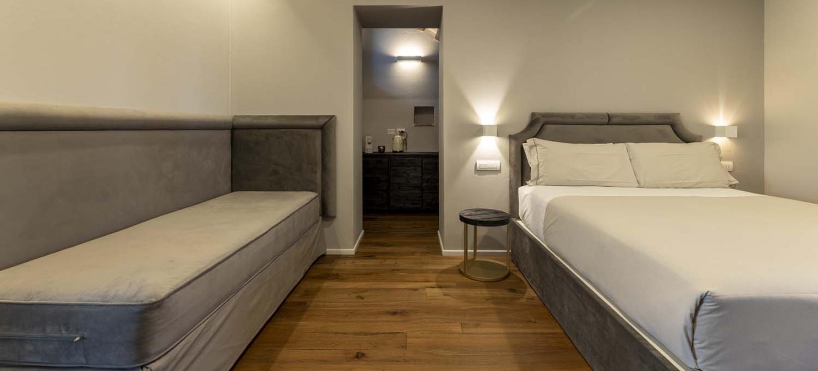 Elegant room with cozy bed, soft lighting, and wooden floor.