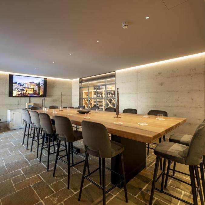 Sala elegante con tavolo in legno, sedie morbide e atmosfera accogliente.