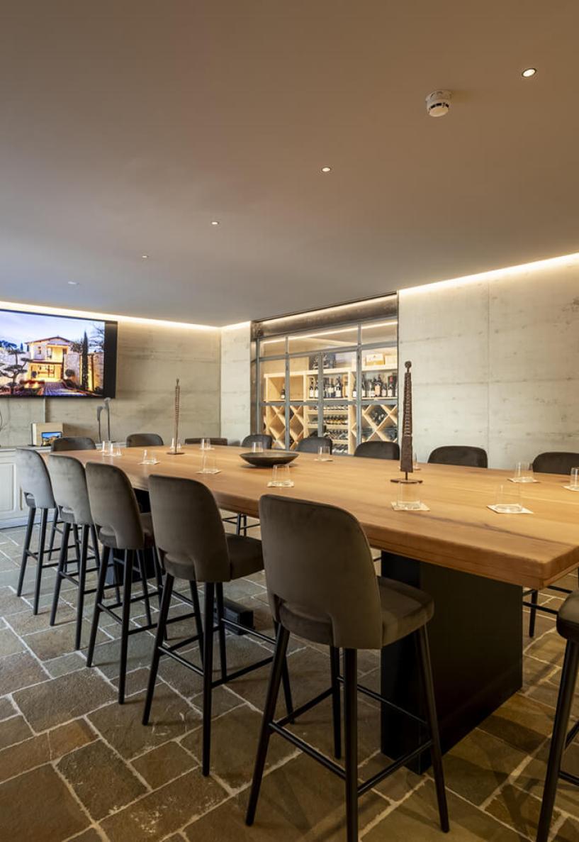 Sala elegante con tavolo in legno, sedie morbide e atmosfera accogliente.